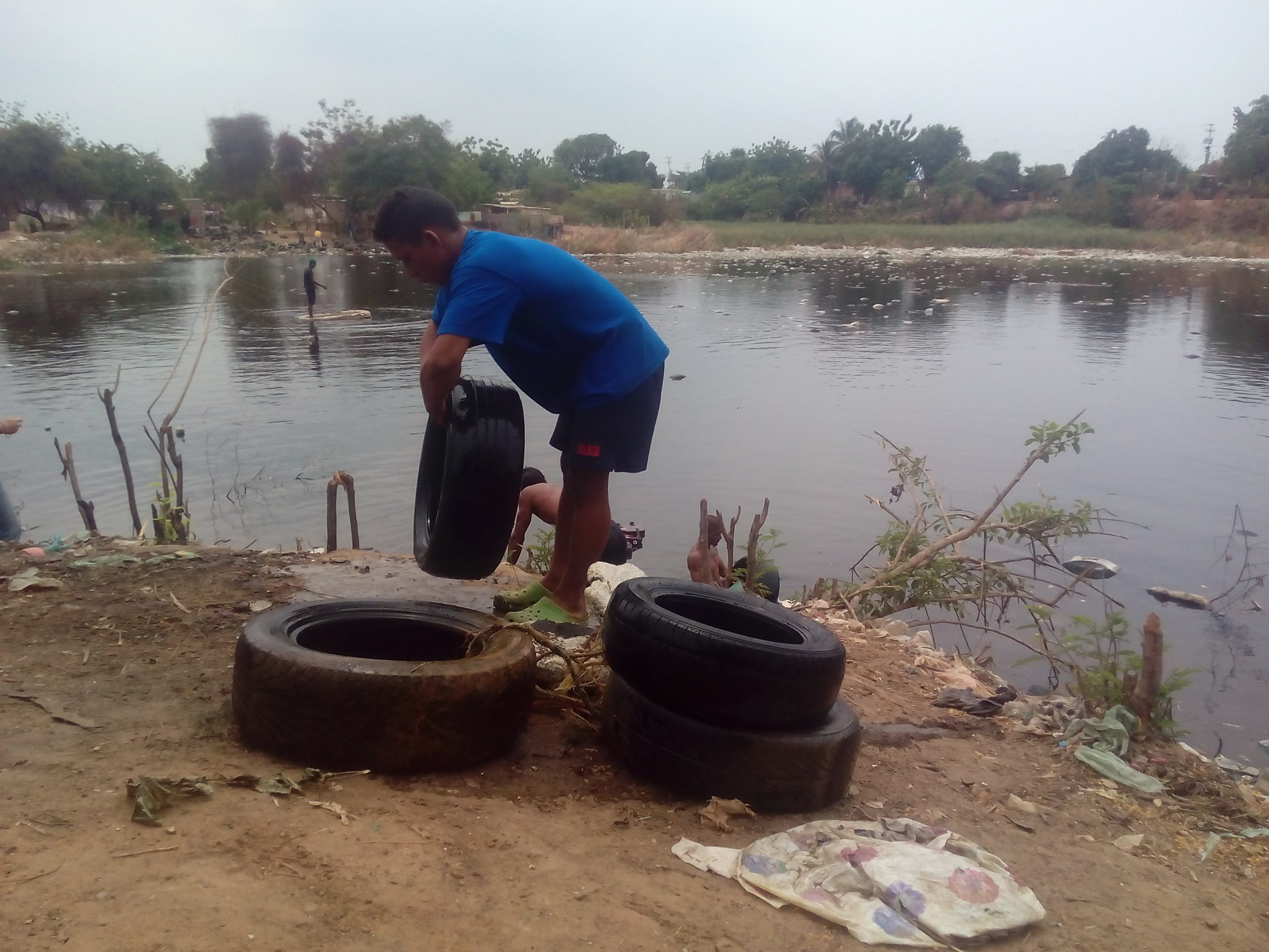 Entre aguas negras y sipa, ellos pescan cauchos para ganarse la vida